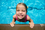 young girl with beach ball at the pool